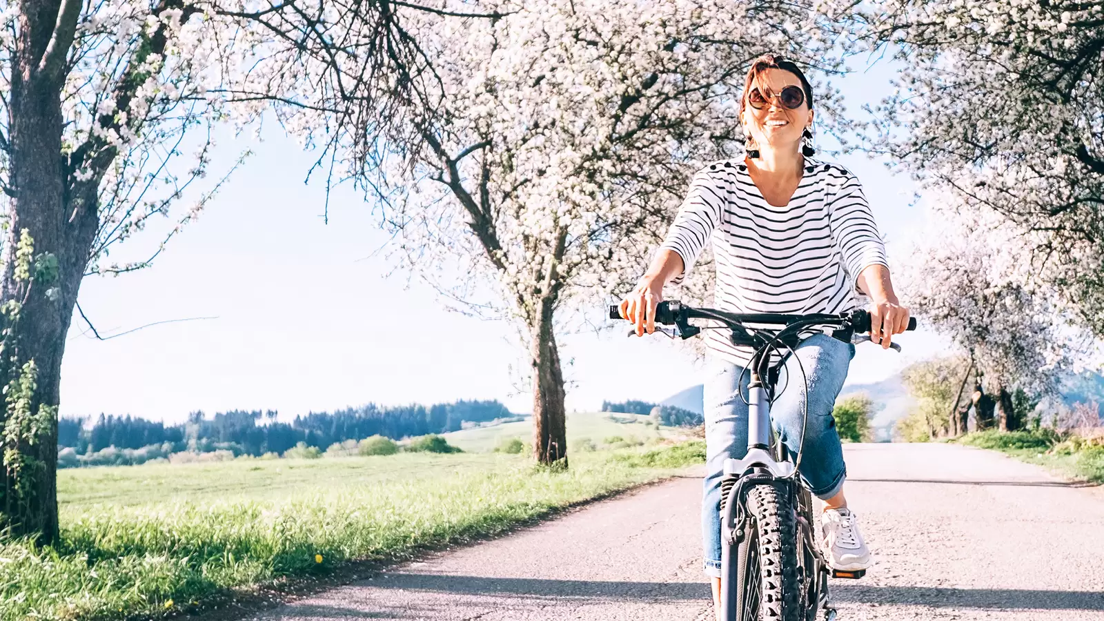 Frau fährt mit Fahrrad durch die Natur