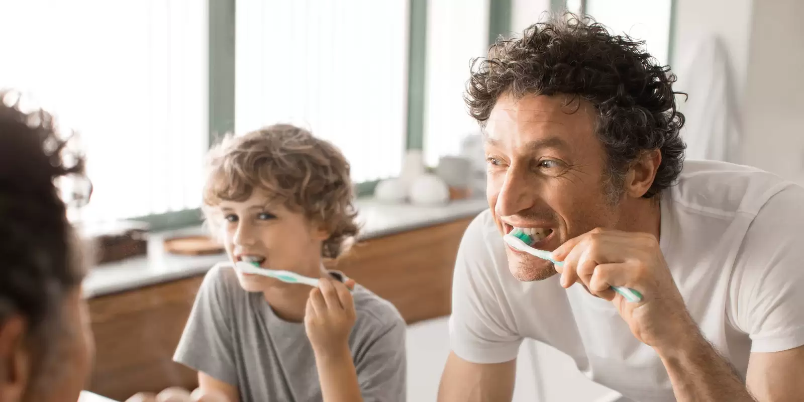 Kind putzt Zähne vor dem Spiegel