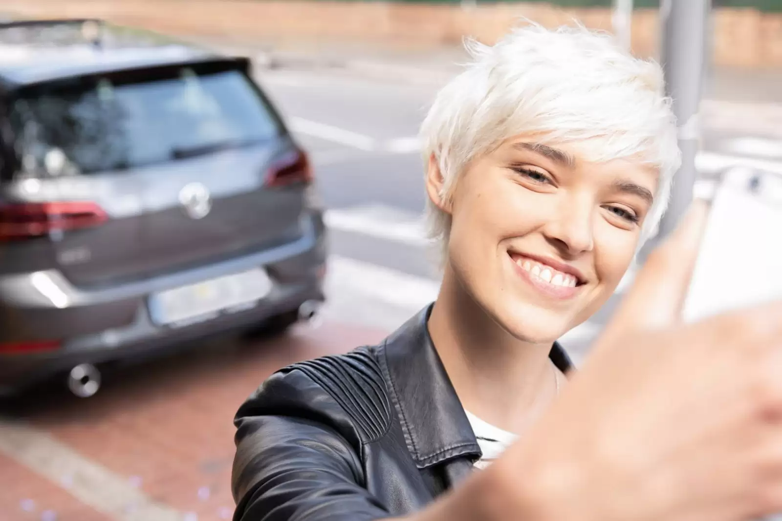 Frau macht Selfie von sich mit Ihrem Auto