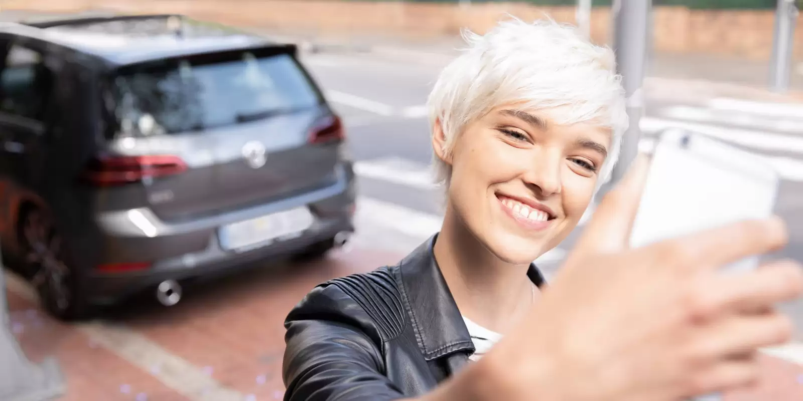 Frau macht Selfie von sich mit Ihrem Auto