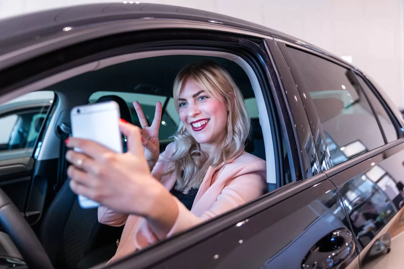 Auszubildende macht Selfie in erstem Leasing-Auto